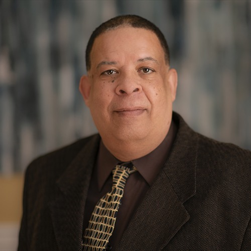 man in brown suit and shirt with tie