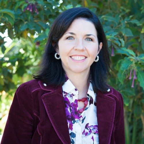 woman smiling in front of greenery